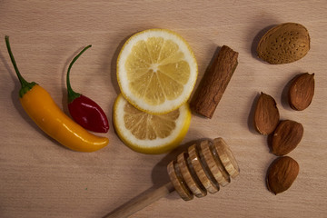 Fototapeta na wymiar Lemon, nuts, spices and chili on board