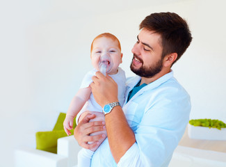 infant baby receives a nebulizer treatment through the facial mask