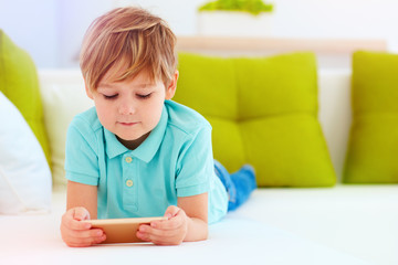 Fototapeta premium cute kid playing games on smartphone