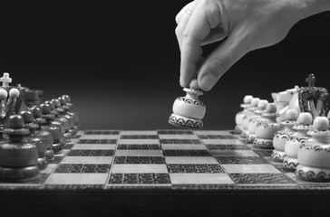 Male hand moving white pawn at the beginning of chess game