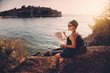 Woman traveler with map with map near sea