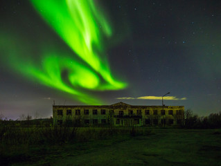Polar lights in the sky over the abandoned building