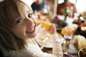 Little Girl Eating Corn Thanksgiving Celebration Concept