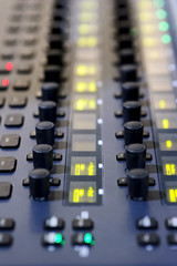 Sound mixer, professional audio mixing console with yellow, green, red lights and buttons 