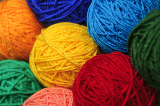 Woolen yarn balls, skeins of tangled colorful sewing threads, selective focus 