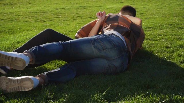 Couple makng summersault, tumble and turn handsprings on grass in slow mo