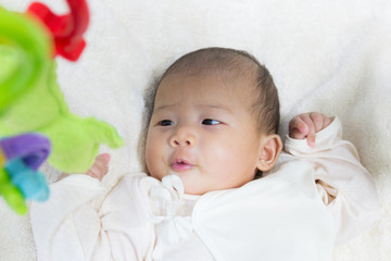 Close - Up Two month old new born asian cute baby playing on pla