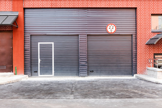 closed brown corrugated metal gate, wall of warehouse front view