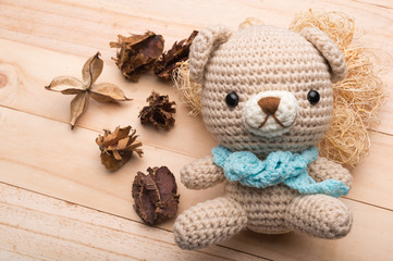 Knitted teddy bear on wood background