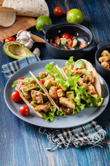 Authentic mexican tacos with chicken and salsa with avocado, tomatoes and chillies