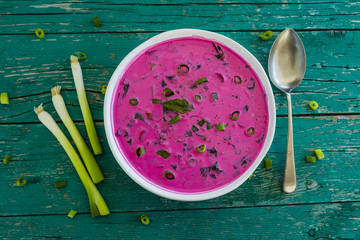 Cold soup with beetroot and vegetables on wooden table. Vegetarian food.