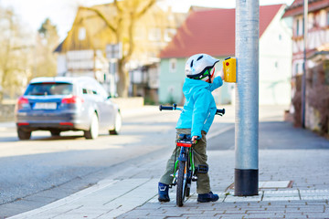 Little preschool kid boy riding with his first green bike