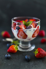 Yogurt with fresh berries fruit and chia seeds on stone background. 