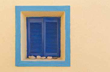 detail of traditional Cycladic house on Santorini with window with closed shutters