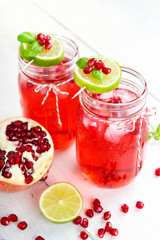 Two glasses with red pomgranate juice, lemon and mint.