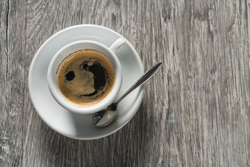 Cup of coffee on wooden table, top view