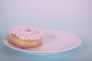 Iced doughnut on a light blue background Vintage Retro Filter.