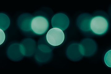 Bokeh dark green circles on black background. Abstract music background.