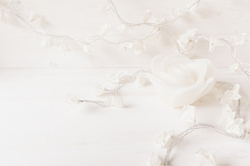 Obraz na płótnie Canvas Paper white flowers and candle rose on white wooden background. Soft home decor.
