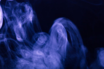Cloud of smoke on black background. Selective focus. Toned