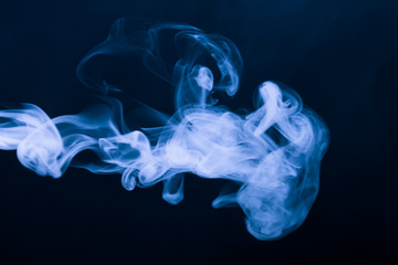 Cloud of smoke on black background. Selective focus. Toned