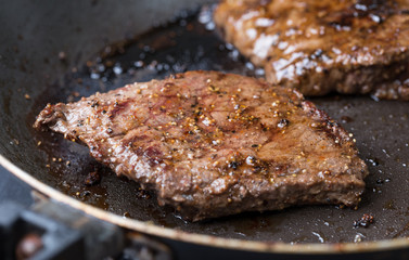 steaks cooking in a pan