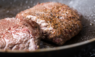 steaks cooking in a pan