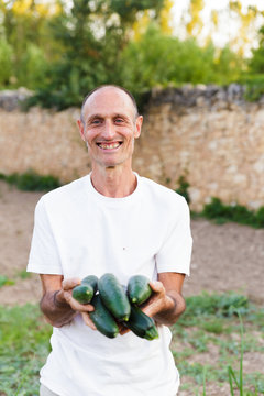 Smilling farmer holding squashes in hands