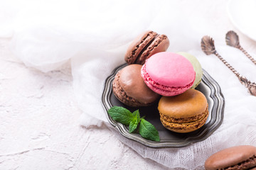 Colorful almond cookies macaron or macaroon on light background, vintage card, holiday food concept, copy space for text.