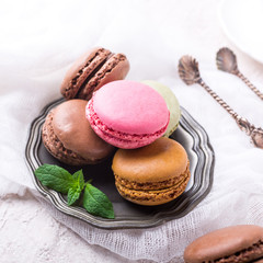 Colorful almond cookies macaron or macaroon on light background, vintage card, holiday food concept, copy space for text.