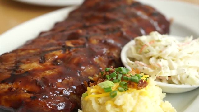 Barbecue baby pork ribs spare with with juicy sauce coleslaw and mashed potatoes