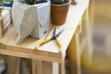 Pliers or tools placed on a wooden table.