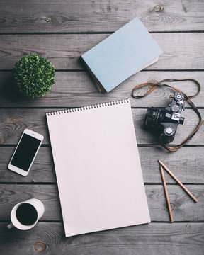 Directly above shot of technologies and writing instruments with black coffee at table