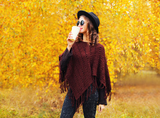 Fashion autumn style pretty young woman with coffee cup wearing