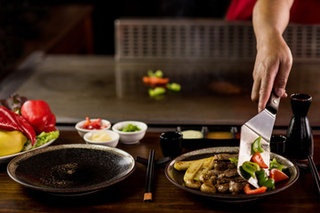 Chef placing freshly cooked bell peppers to serve an order.