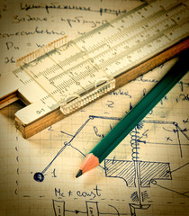 pencil and a slide rule on the old page with the calculations in
