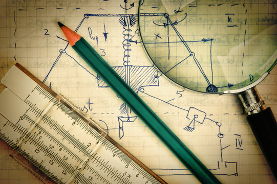 magnifying glass and a slide rule on the old page with the calcu