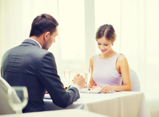 Fototapeta premium smiling couple eating dessert at restaurant