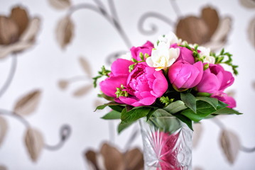 Luxurious pink, red and white peonies bouquet with leaves  buds in the crystal vase