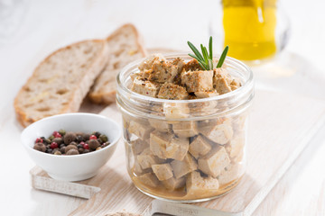 marinated feta in a glass jar on a wooden board