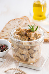 marinated feta in a glass jar, vertical, closeup