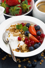 muesli with fresh berries and yogurt for breakfast, closeup 