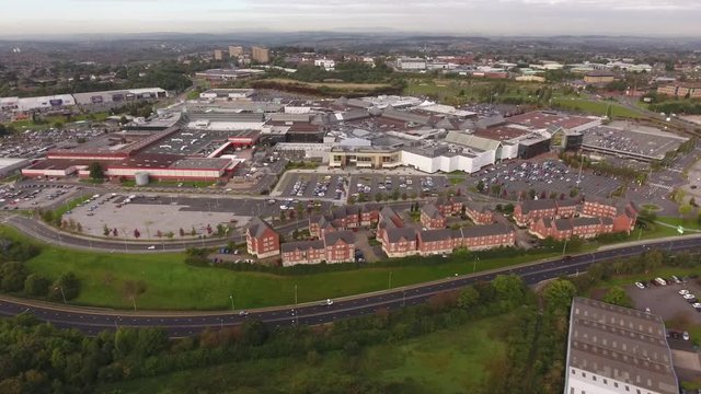 Aerial view of a large retail park and dual carriageway with traffic.