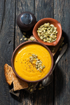 Delicious pumpkin soup in a bowl, vertical top view