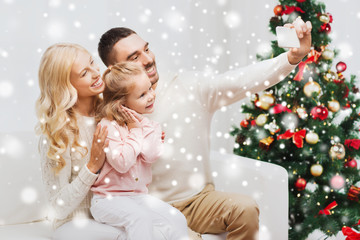 family taking selfie with smartphone at christmas