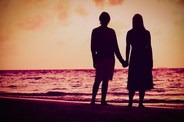 romantic couple holding hands at sunset