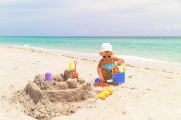 cute little girl play with sand on beach