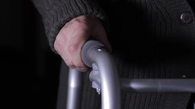 Close Up Of A Very Old Woman"s Hand Gripping The Handle Of The Walker