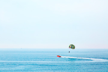 Parasailing in Adriatic sea, Montenegro. Colored parasail wing in blue sky.
