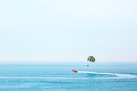 Parasailing in Adriatic sea, Montenegro. Colored parasail wing in blue sky.